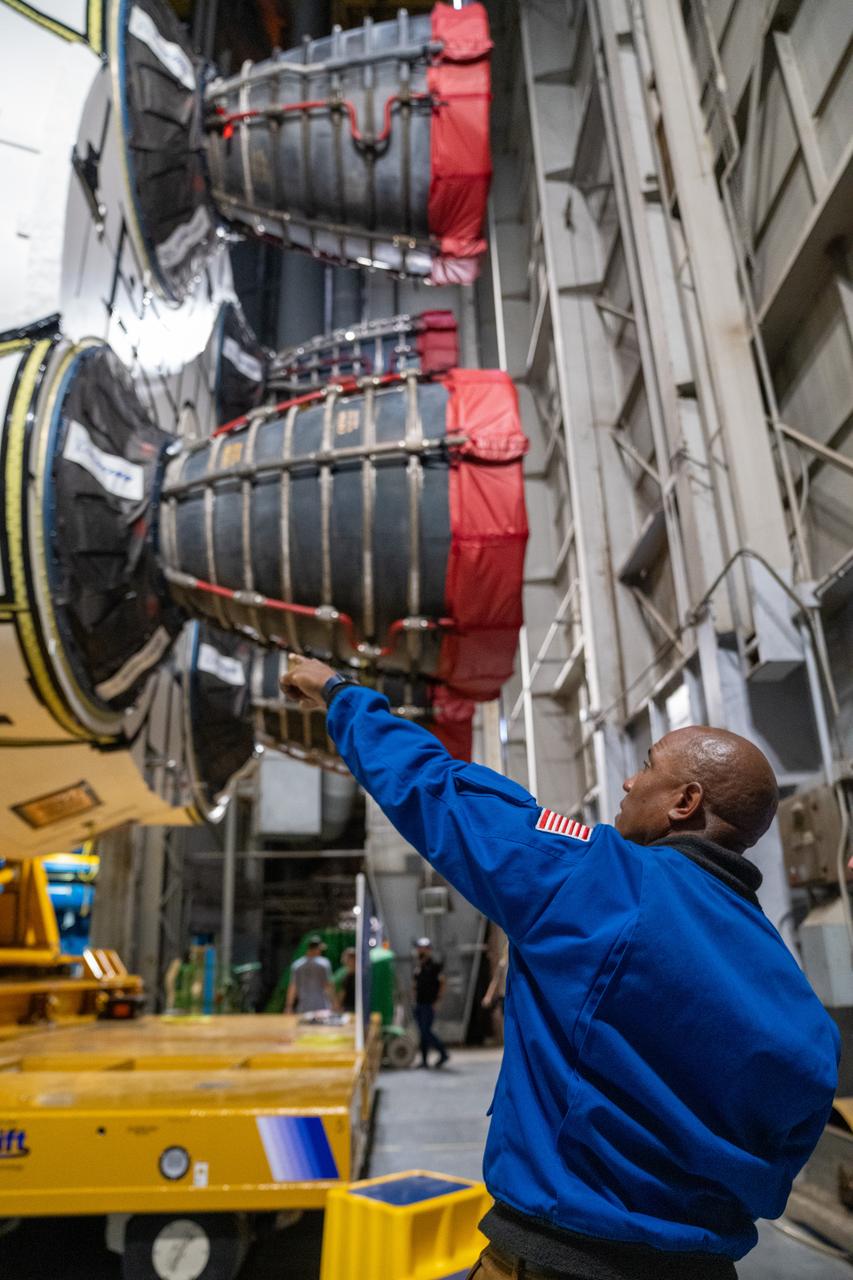 NASA astronaut Victor Glover views the core stage of the SLS (Space Launch System) rocket that will help power Artemis II at NASA’s Michoud Assembly Facility in New Orleans July 15. Glover will pilot Artemis II, the first crewed mission of NASA’s Artemis campaign. Crews moved the 212-foot-tall core stage with its four RS-25 engines to Building 110 at NASA Michoud prior to rolling it out to NASA’s Pegasus barge July 16 for delivery to NASA’s Kennedy Space Center in Florida. The core stage has two giant propellant tanks that collectively hold more than 733,000 gallons of super cold liquid propellant to feed the stage’s four RS-25 engines. Together, the engines produce more than 2 million pounds of thrust to help send astronauts inside NASA’s Orion spacecraft to venture around the Moon for Artemis II.  NASA is working to land the first woman, first person of color, and its first international partner astronaut on the Moon under Artemis. SLS is part of NASA’s backbone for deep space exploration, along with the Orion spacecraft, supporting ground systems, advanced spacesuits and rovers, the Gateway in orbit around the Moon, and commercial human landing systems. SLS is the only rocket that can send Orion, astronauts, and supplies to the Moon in a single launch.  